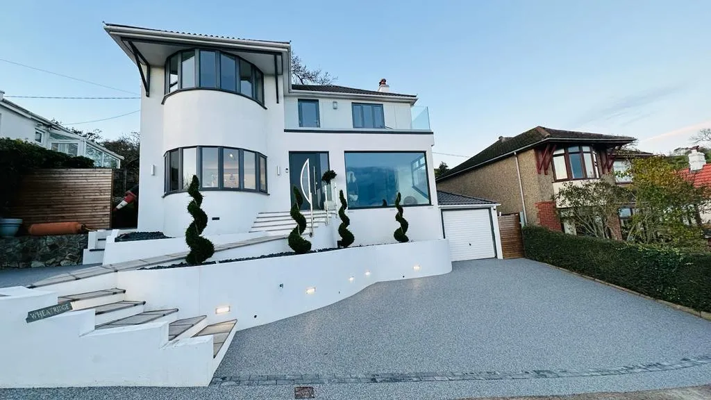 White modern house with a clean driveway infront