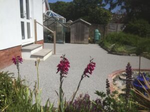 Grey resin patio with flowers infront