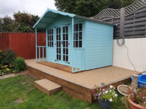 blue shed on a resin patio with steps
