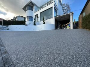 grey drive leading to large white house